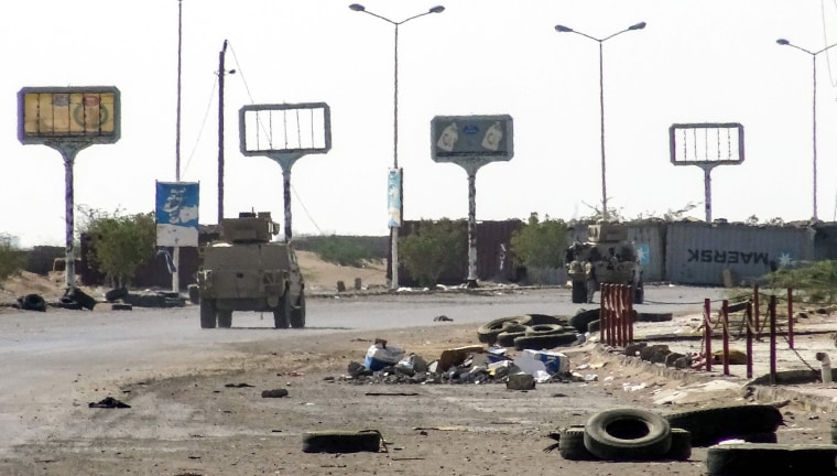 Image: Armoured vehicles of the Yemeni pro-government forces are seen driving past destruction in an industrial district in the eastern outskirts of the port city of Hodeida