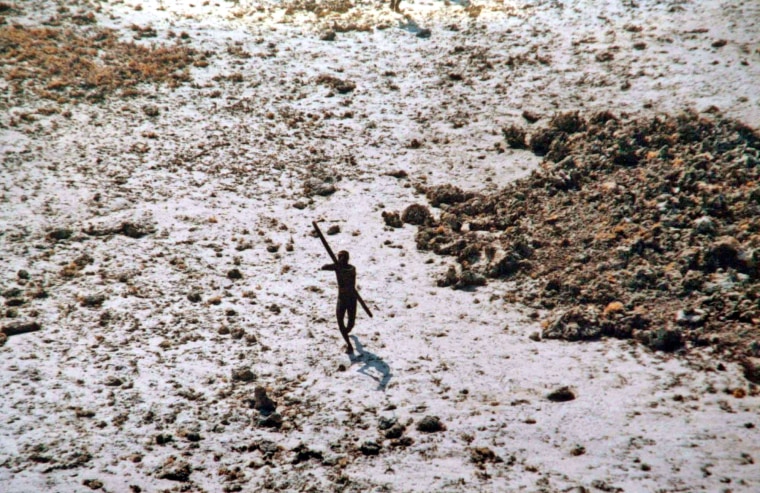 Image: A tribesman aims his bow at an Indian Coast Guard helicopter in 2004.