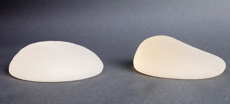 Close-up of lopsided breast implants on a table