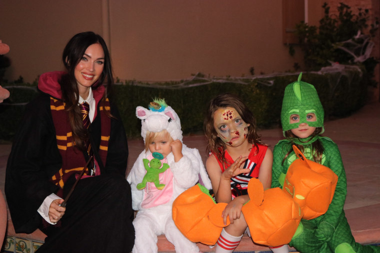 Proud mama Megan Fox, host of the Travel Channel series "Legends of the Lost," on Halloween in her Hogwarts robes with her three sons -- a unicorn, a zombie cheerleader and Gekko from "PJ Masks."