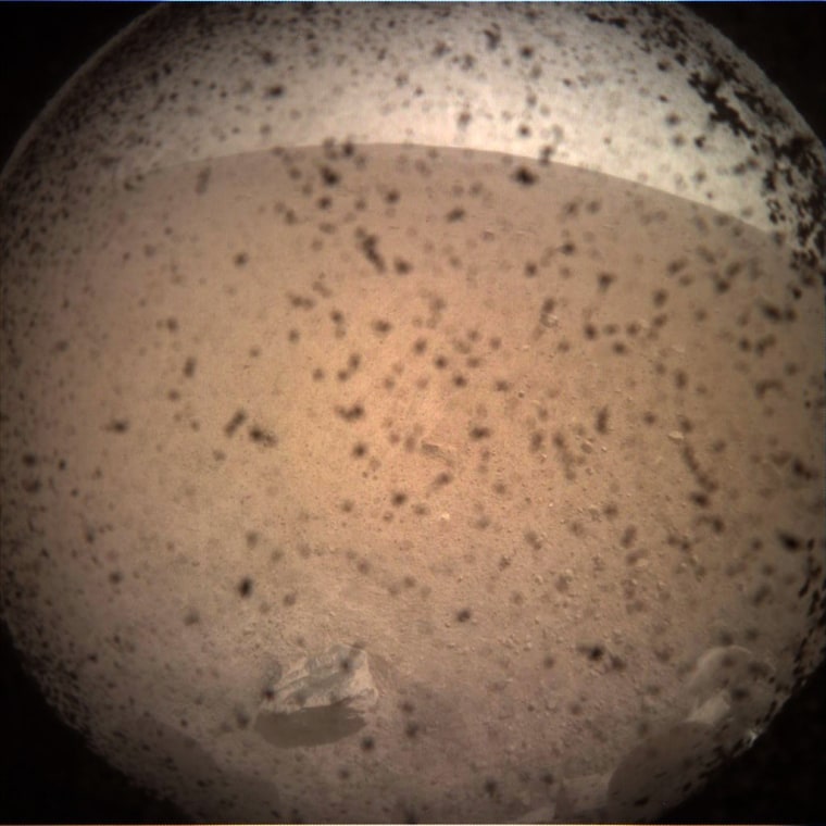 Debris is seen on the lens in the first image from NASA's InSight lander after it touched down on the surface of Mars on Nov. 26, 2018.