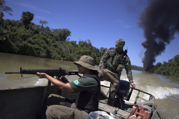 Ibama agents navigate the Novo River after setting fire to a structure that was being used by people mining illegally in the Jamanxim National Forest in the Amazon basin in Brazil on June 24, 2017.