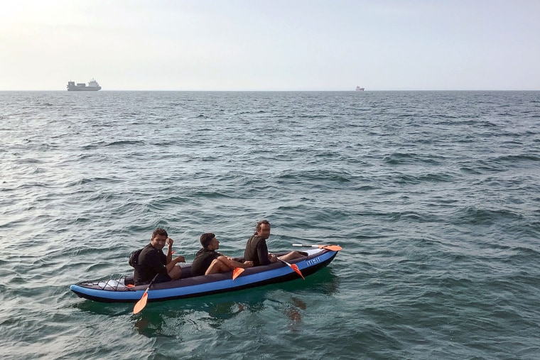 Image: Three migrants who were attempting to cross the English Channel in an inflatable canoe