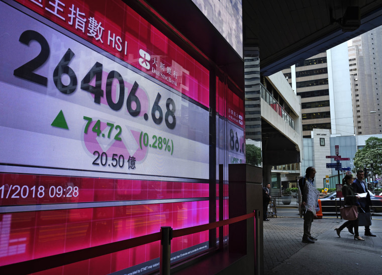 Image: People walk past a bank electronic board showing the Hong Kong share index at Hong Kong Stock Exchange