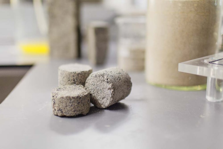 The bio-bricks are created through a natural process called microbial carbonate precipitation