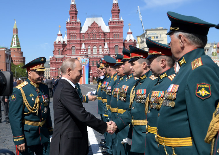 Russian President Vladimir Putin, second left, and Russian Defense Minister Sergei Shoigu, left, congratulate Russian officers after the Victory Parade marking the 73rd anniversary of the defeat of the Nazis in World War II, in Moscow on May 9, 2018.