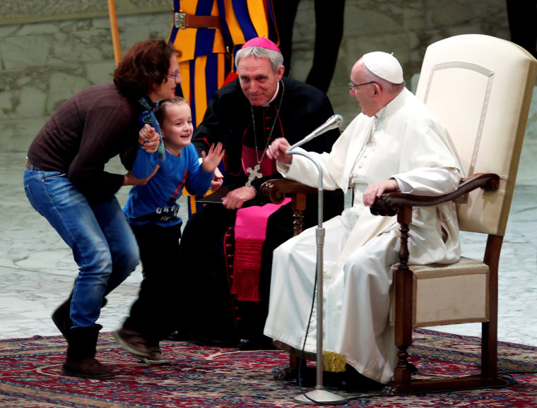 Pope Francis reacts as a child approaches him onstage during a general audience at the Vatican on Nov. 28, 2018.