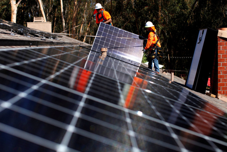 Image: Solar installers from Baker Electric place solar panels on the roof of a residential home in Scripps Ranch, San Diego
