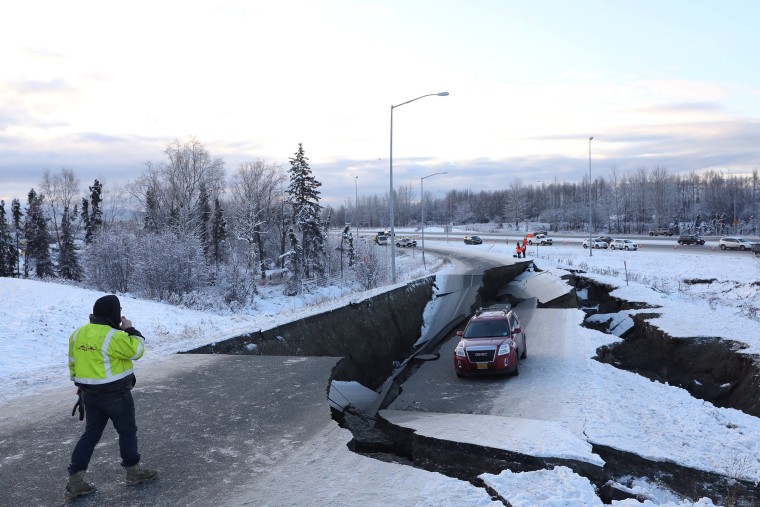 Image: A stranded vehicle lies on a collapsed roadway near the airport after an earthquake in Anchorage