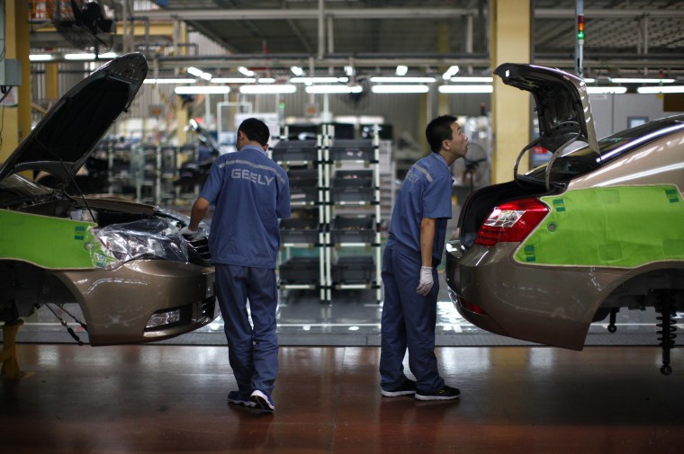 Image: Employees work along a Geely Automobile Corporation assembly line in Cixi