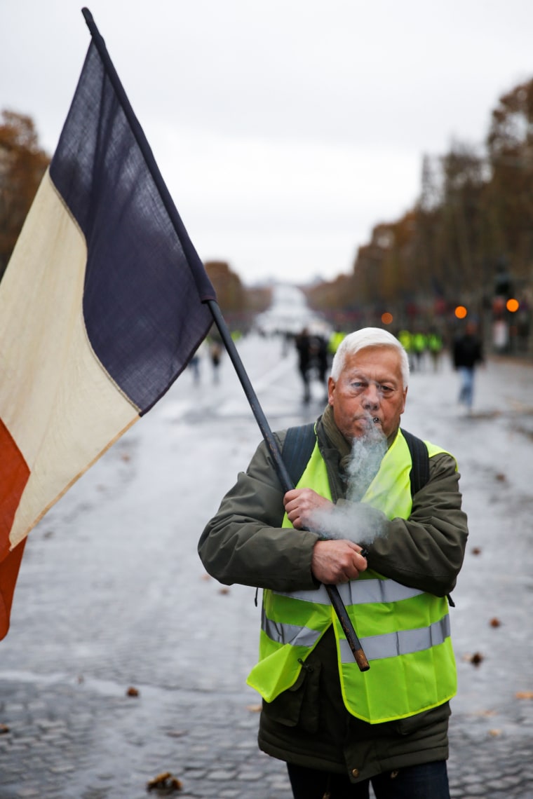 Image: A demonstrator holds a French flag during protests in Paris