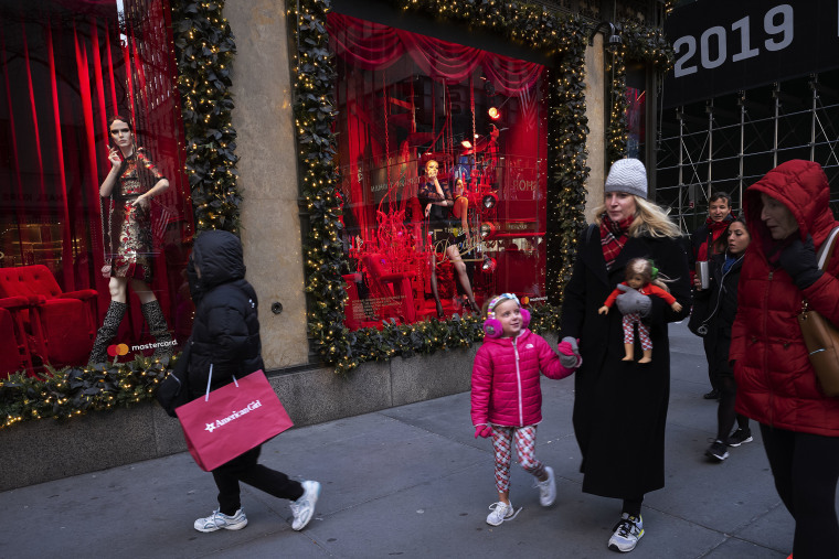 People walk by holiday windows at Saks Fifth Avenue, Wednesday, Dec. 5, 2018, in New York.