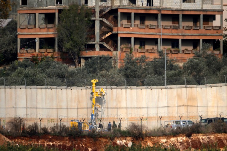Image: Israeli soldiers standing by machinery near the border wall with Lebanon