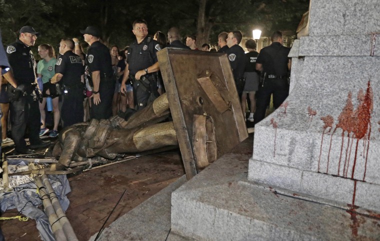 Image: Police stand guard after the confederate statue known as Silent Sam was toppled by protesters on campus at the University of North Carolina in Chapel Hill