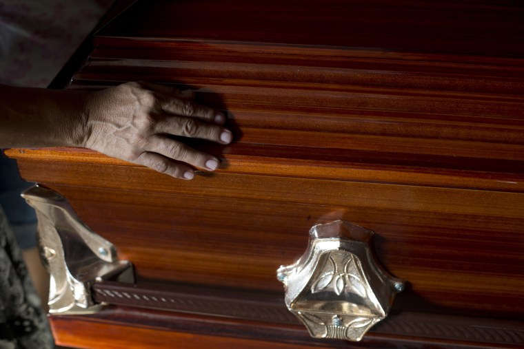 Image: A mourner touches Wilmer Gerardo Nunez's casket at the end of the wake on Oct. 31, 2018.