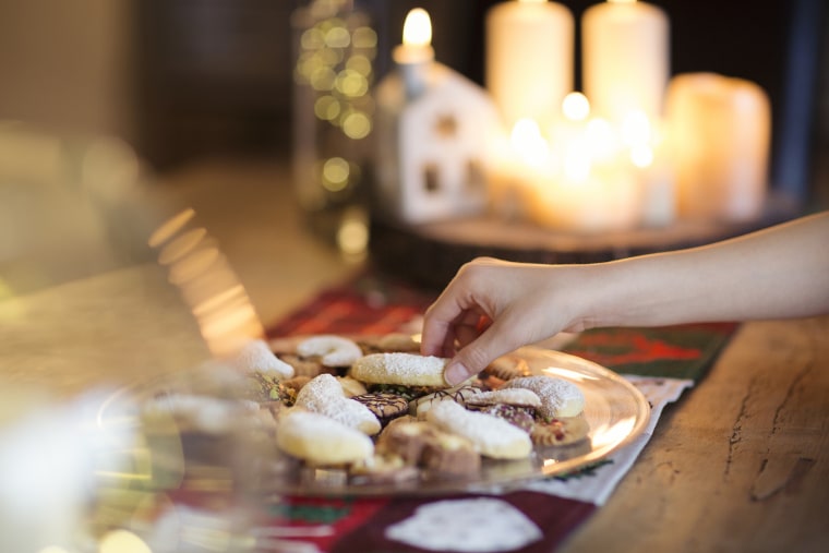 Image: Child taking a traditional German Christmas cookie off a plate on a table