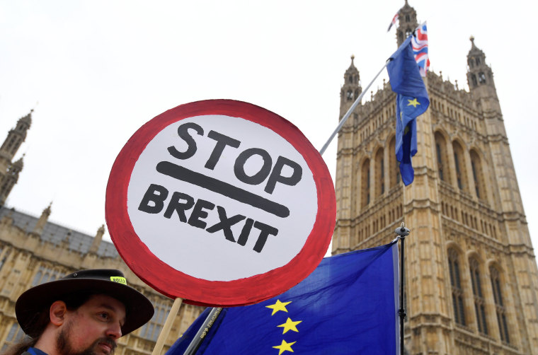 Image: Anti-Brexit protesters wave flags and placards opposite the Houses of Parliament in London