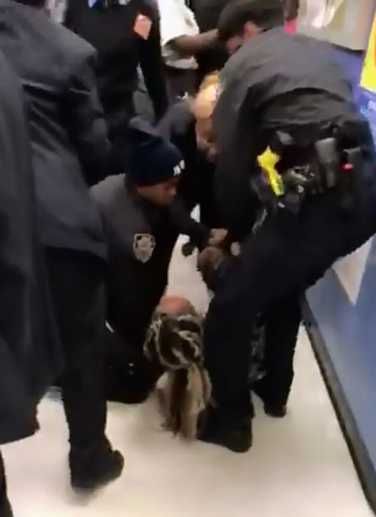 Image: Police officers wrestle a baby from a mothers arms in Brooklyn.