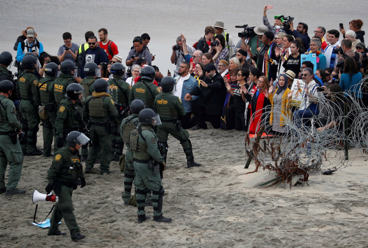 Faith leaders gather in support of the migrant caravan in front of U.S. Customs and Border Protection (CBP) officials, at the border fence between the United States and Mexico, as seen from Tijuana