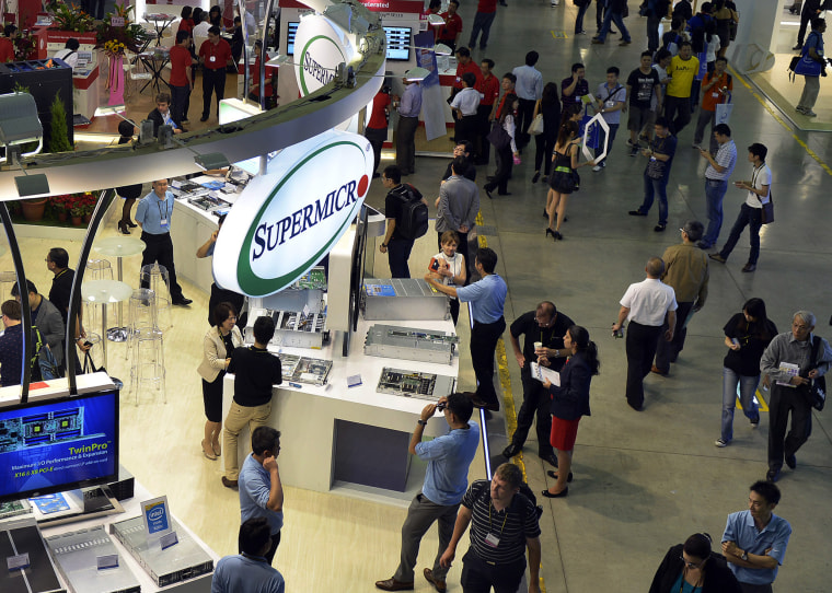 Visitors walk past the Supermicro booth