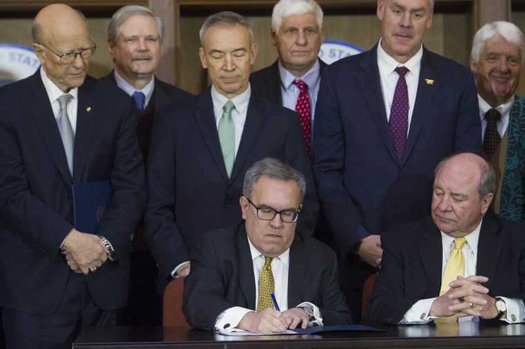 Image: Acting EPA Administrator Andrew Wheeler, left, signs an order withdrawing federal protections for waterways and wetlands at EPA headquarters in Washington on Dec. 11, 2018.