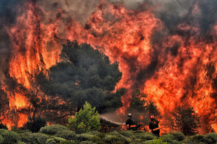 Image: Firefighters try to extinguish flames in the village of Kineta, Greece