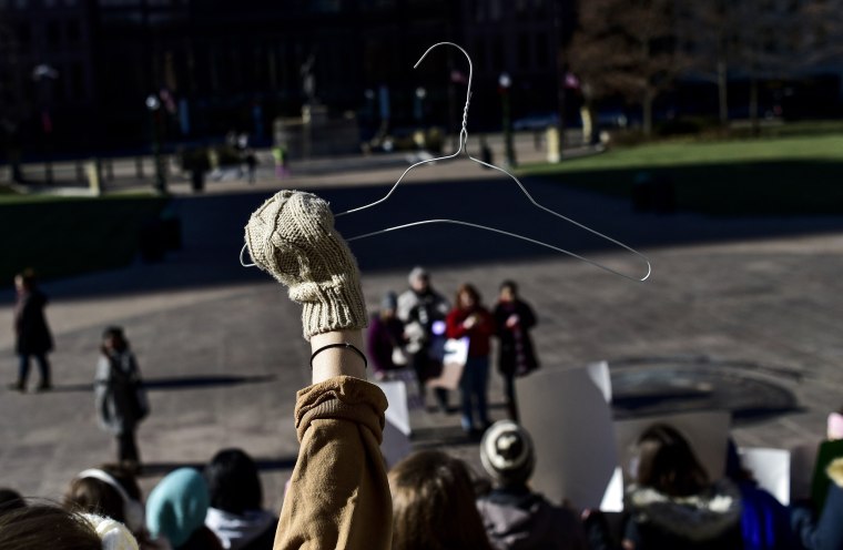 Image: A protester holds a hanger during a demonstration against a proposed Ohio bill that bans abortion once a fetal heartbeat is detected in Columbus on Dec. 12, 2018.