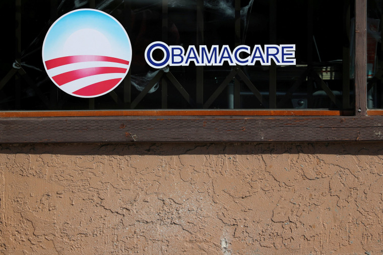 Image: A sign on an insurance store advertises Obamacare in San Ysidro