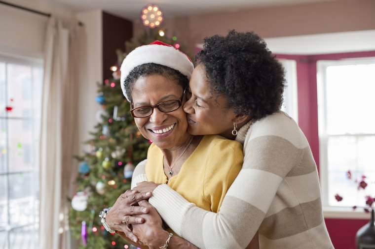 Image: Mom and adult daughter hugging at Christmas tree