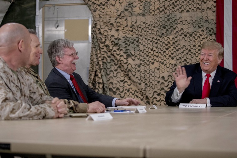 Image: President Donald Trump jokes with National Security Adviser John Bolton and senior military leadership as he speaks to the media at Al Asad Air Base.