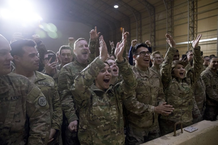 Image: U.S. troops cheers as President Donald Trump speaks at a hanger rally at Al Asad Air Base.