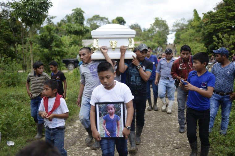 A boy carries a picture Jakelin Caal as her coffin is taken from Raxruha to the cemetery in San Antonio Secortez