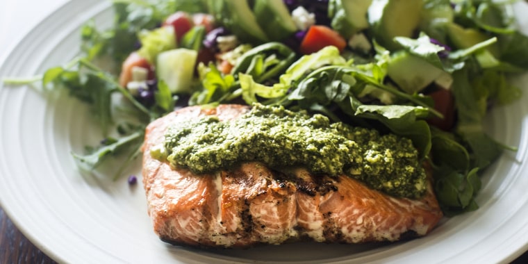 Salmon fillet topped with arugula pesto and salad