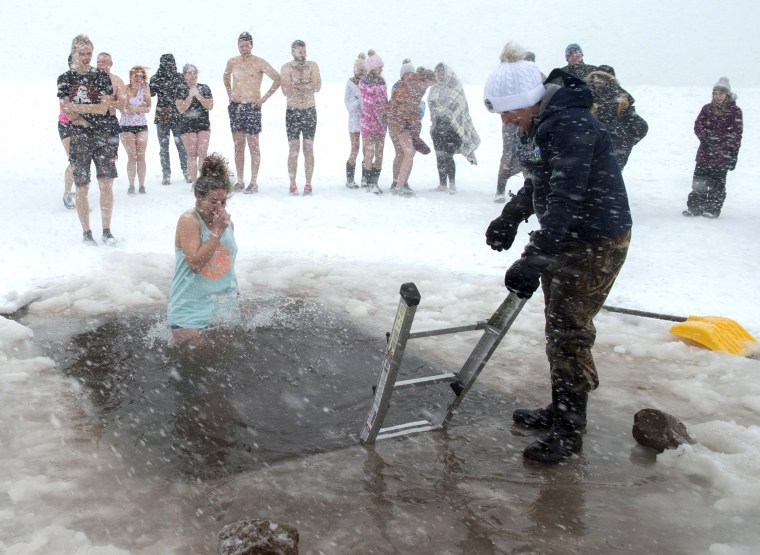 Image: Swimmers brave stormy conditions during the New Year's Polar Bear Dip on Prince Edward Island in Canada.