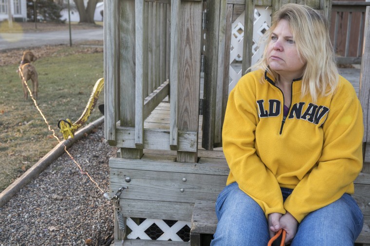 Danette Lake sits on her front porch after walking her dogs, Zoe and Chloe