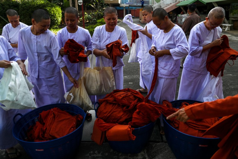Image: Devotees in white robes return saffron robes after ending their novice monkhood