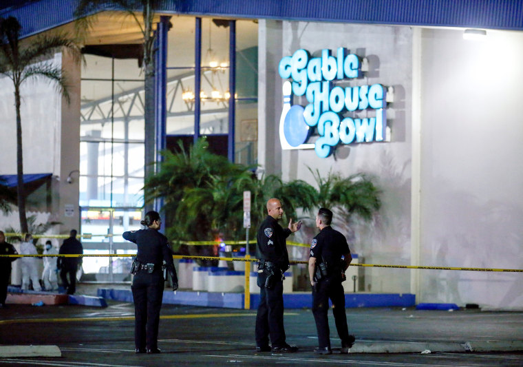 Image: Police officers investigate a shooting at a bowling alley in the Los Angeles suburb of Torrance