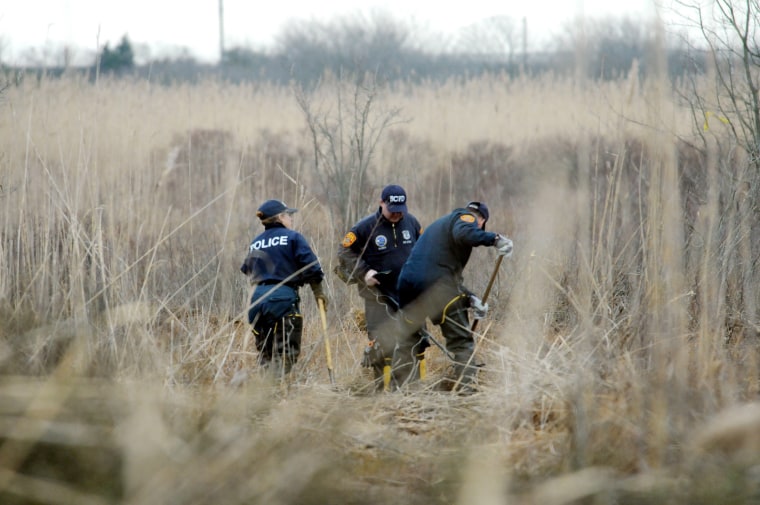 Crime scene investigators use metal detectors to search a marsh for the remains of Shannan Gilbert