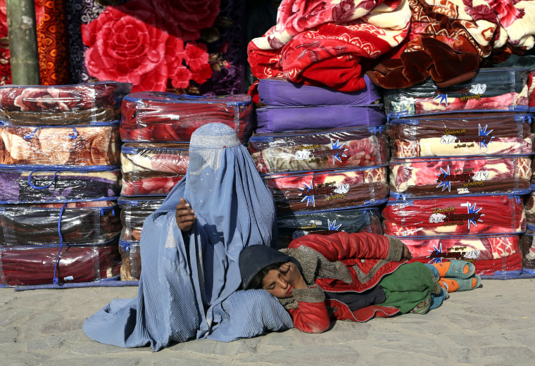 Image: A woman and child beg on a sidewalk in Kabul, Afghanistan.