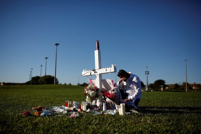 Image: Joe Zevuloni mourns at a memorial for the victims of a shooting at Marjory Stoneman Douglas High School in Parkland, Florida, on Feb. 16, 2018.