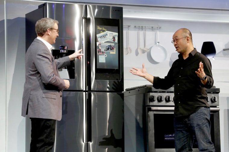 Image: John Herring and Yoon Lee, executives with Samsung Electronics America, post a photo to "Family Board" on a  Family Hub smart refrigerator during a Samsung news conference at the 2019 CES in Las Vegas