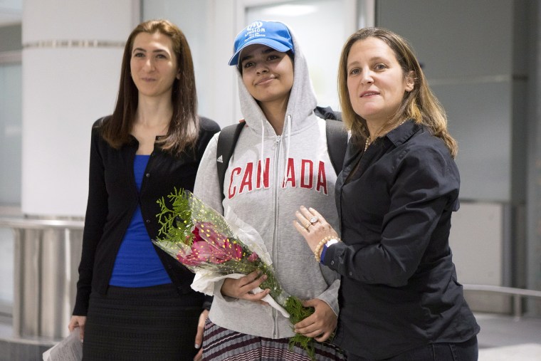 Image: Rahaf Mohammed Alqunun, center, stands with Canadian Minister of Foreign Affairs Chrystia Freeland, right