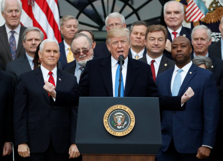 Image: President Donald Trump speaks flanked by Vice President Mike Pence and Senator Tim Scott after the U.S. Congress passed sweeping tax overhaul legislation, on the South Lawn of the White House in Washington