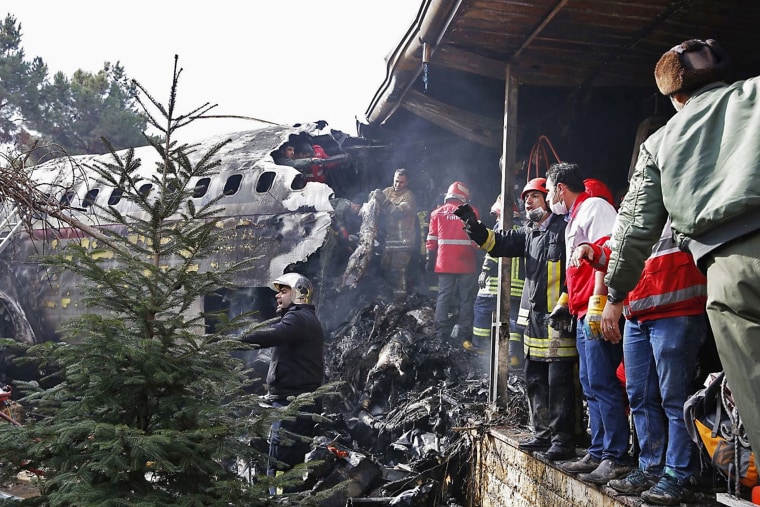 Image: Emergency crews work near the wreckage of the creashed Boeing 707 cargo plane
