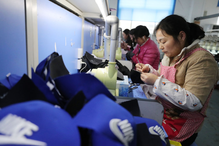 Workers make caps for export in a textile workshop in Lianyungang