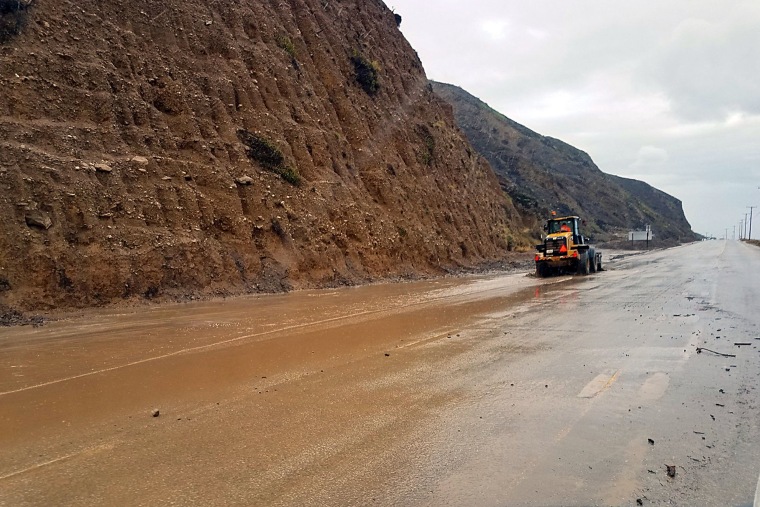 Image: A skiploader clearing a river of mud that has flowed onto Pacific Coast Highway in Malibu