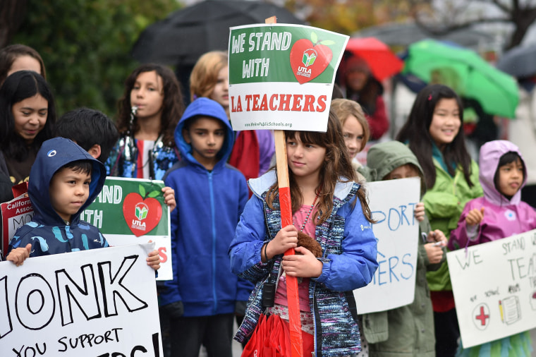 Students stand for a photo after walking the picket line with their teachers and parents