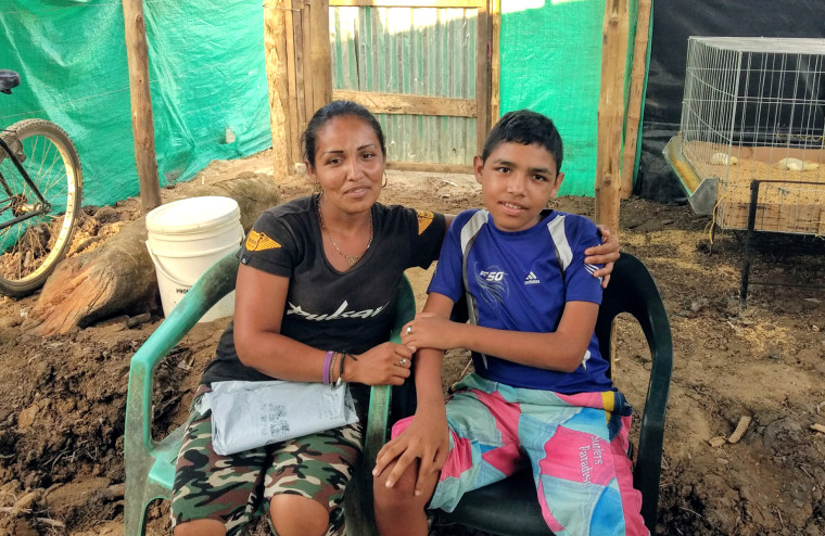 Katerina Vinegas, with her son Jeferson Miranda Vinegas, 14,  at a camp on the Colombia shore of the Arauca River, on Wednesday 16 January 2019.