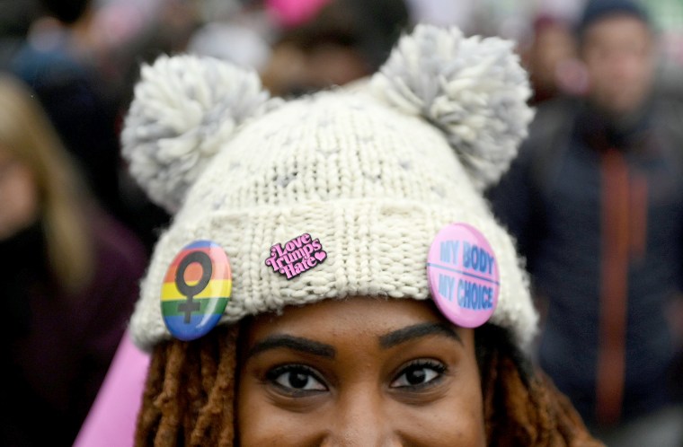 Image: A woman wears a \"Love Trumps Hate\" pin as she participates in the Third Annual Women's March at Freedom Plaza in Washington