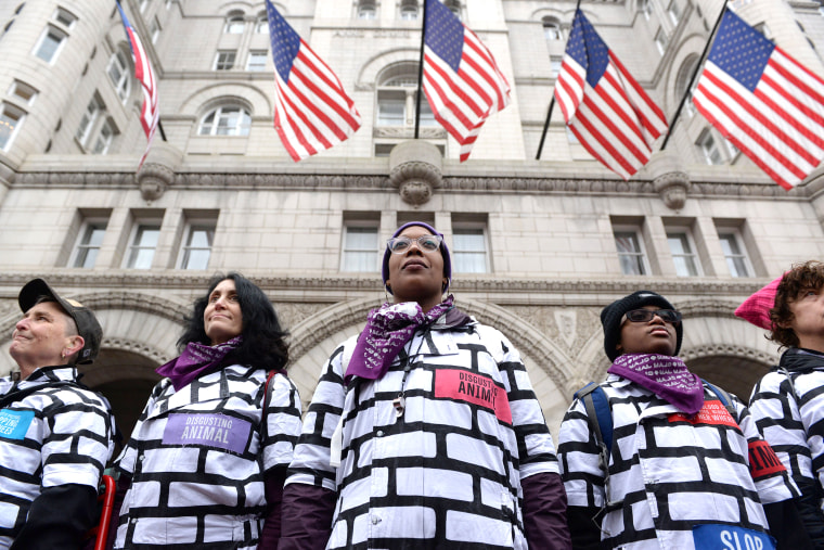 Image: Women wear wall protest outfits as they stand in front of the Trump International Hotel while participating in the Third Annual Women's March in Washington